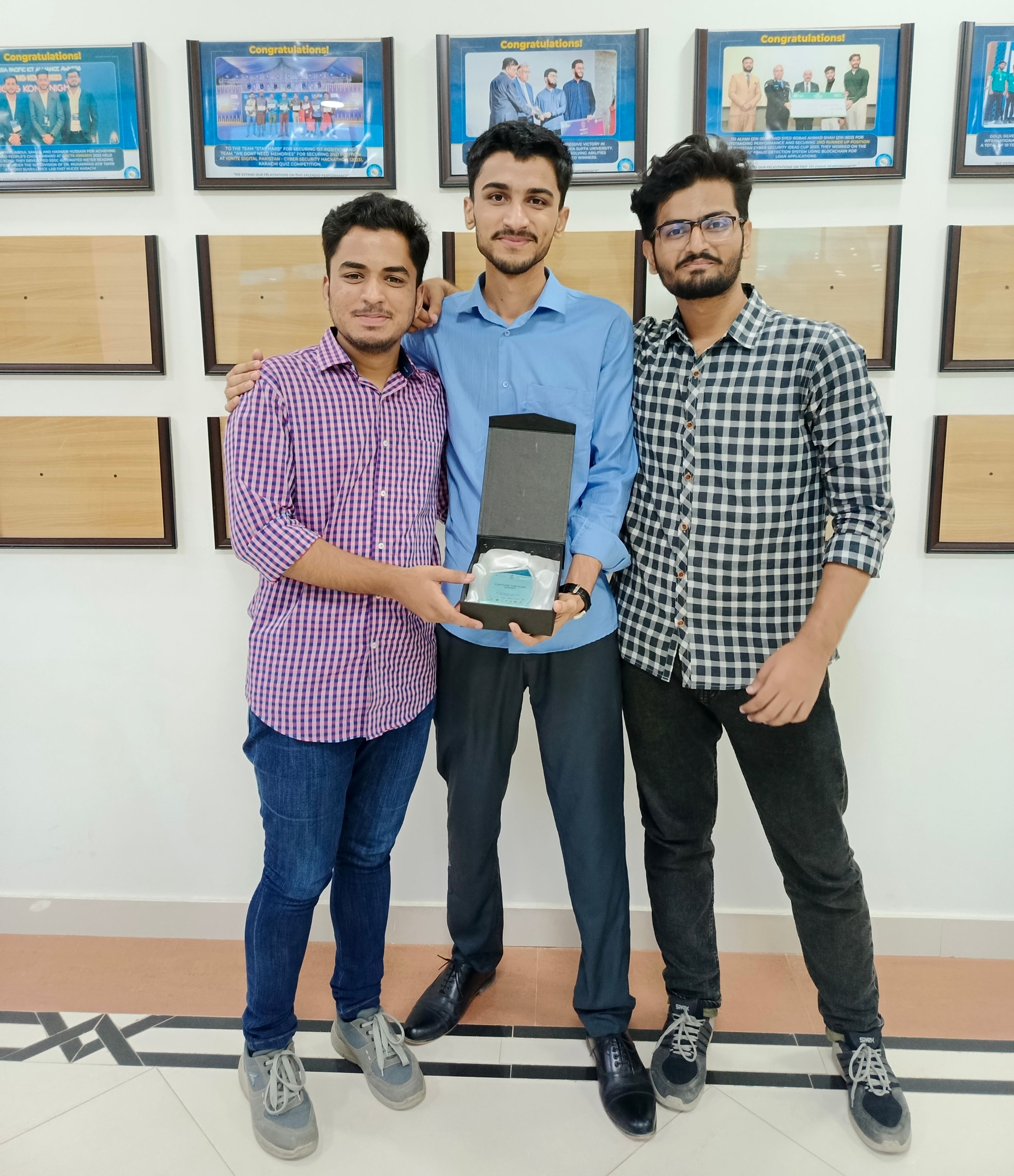 3 boys smiling with a prize